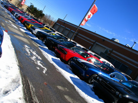 A line of cars for sale at a car dealership.