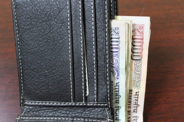 Indian Rupees tucked into a wallet.
