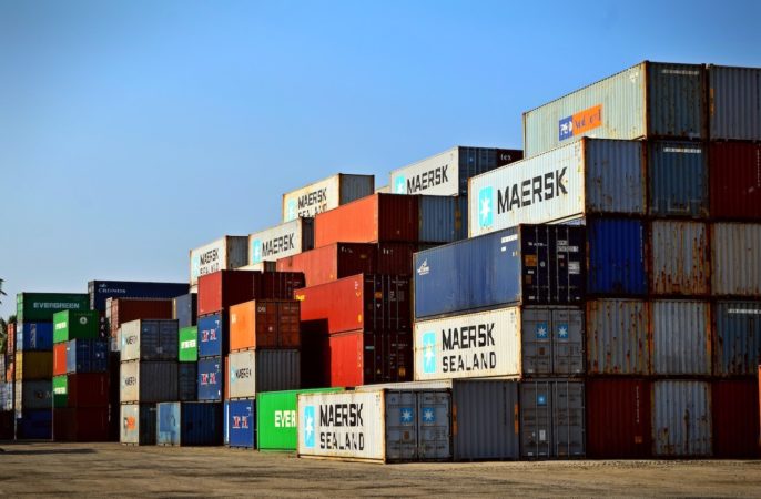 A stack of shipping containers in a shipping yard.
