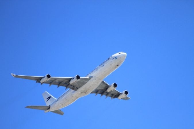 A close-up of an airplane flying in the sky as seen from the ground.