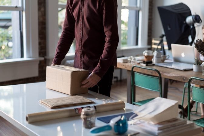 A man preparing a package to be sent for delivery.