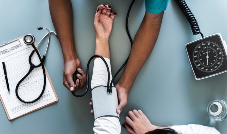A doctor checking his patient's blood pressure.