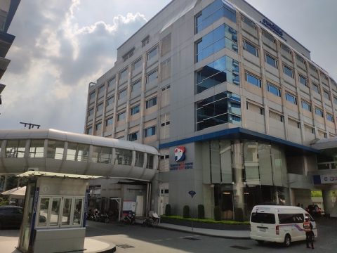 A van parked outside of the entrance to a hospital.