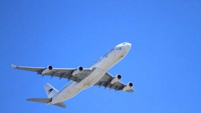 A close-up of an airplane flying in the sky as seen from the ground.