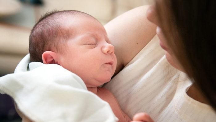A mother holding her newborn in her arms.