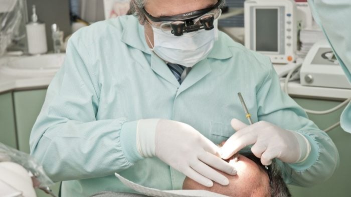 A dentist checking his patient's teeth.