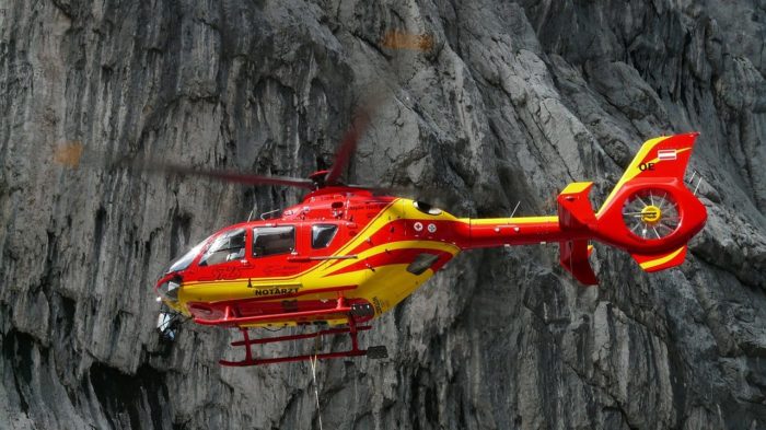 A medical helicopter in the foregroud of some mountains.