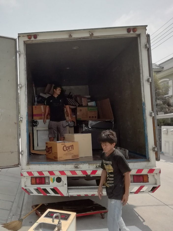 Movers loading a moving truck with boxes and furniture.