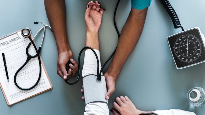 A doctor checking his patient's blood pressure.