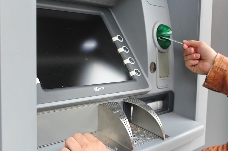 Someone inserting a card into an ATM