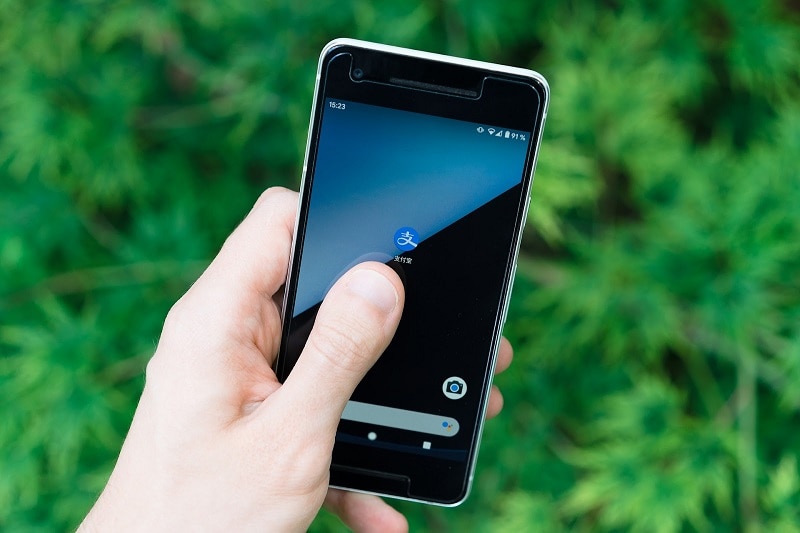 A person about to press the AliPay icon on their phone