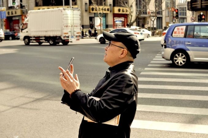 A local admires the view of a temple in downtown Shanghai.