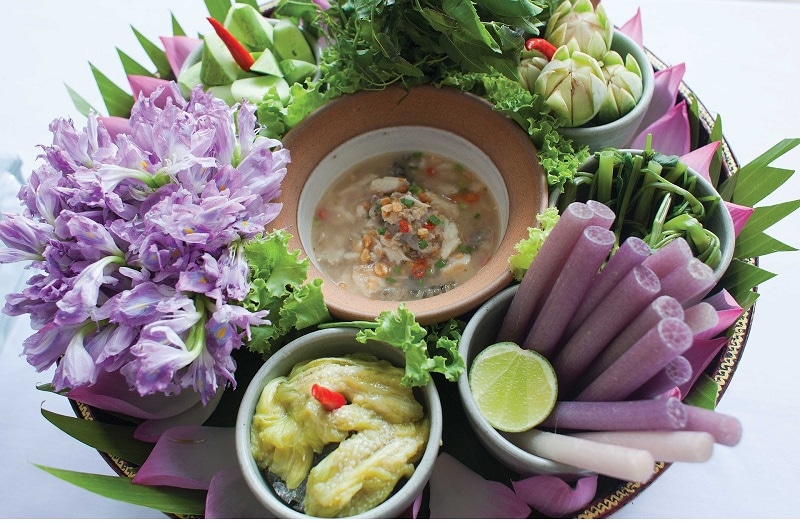 A platter of vegetables, edible flowers, and sauces which are Khmer food in Cambodia.