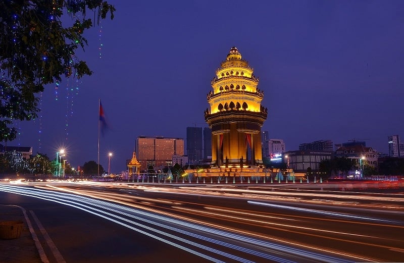 Phnom Penh, Cambodia photo at night with lights from cars and a monument. 