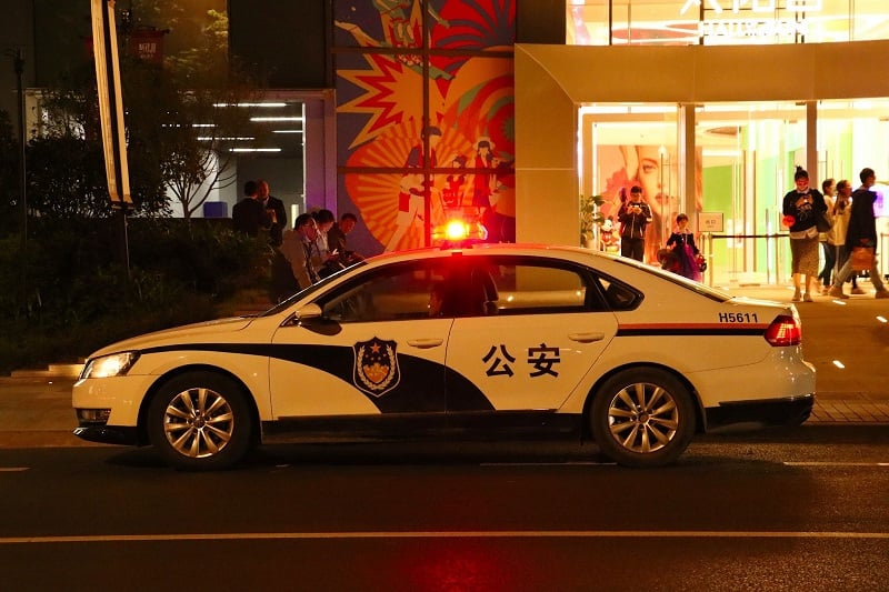 A Chinese police car with flashing lights 