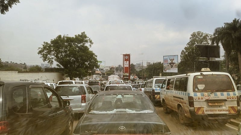 A photo through the windshield of a car in the middle of a busy street in Uganda 