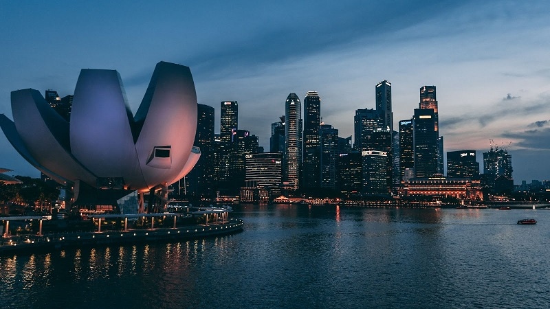 A night time landscape of Singapore with the ArtScience Museum in the foreground. 