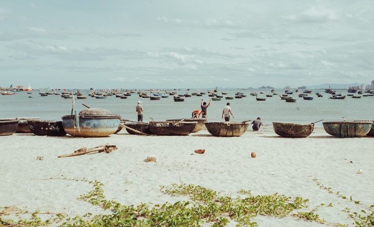Da Nang, Vietnam. View f a beach and the ocean covered in small circular wooden boats. 
