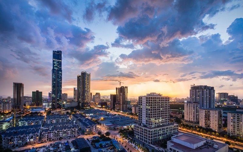Hanoi, Vietnam view of skyscrapers with a sunset and fluffy clouds.