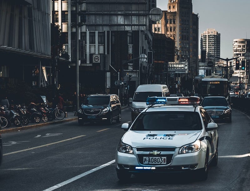 A photo of a Chinese police car on a city street. 