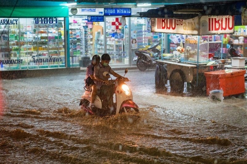 ride a motorcycle under flood. 