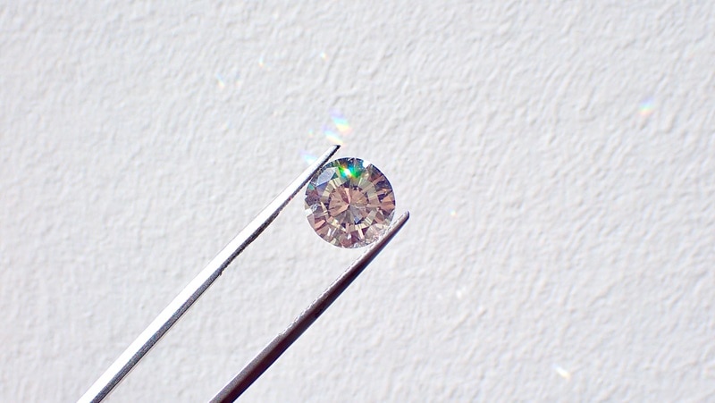 A photo of tweezers holding a diamond.