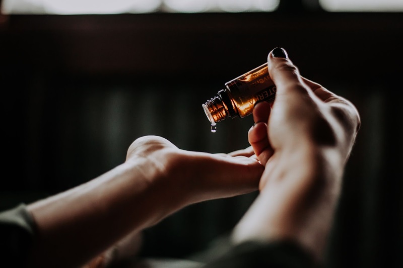 essential oils being dripped onto a hand 