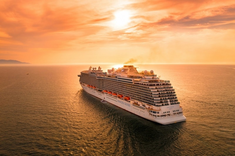 A cruise ship setting off into the sunset.