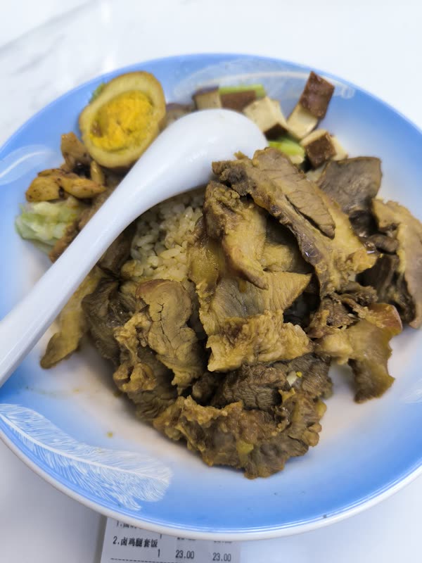 A bowl of braised pork over rice with a soft egg