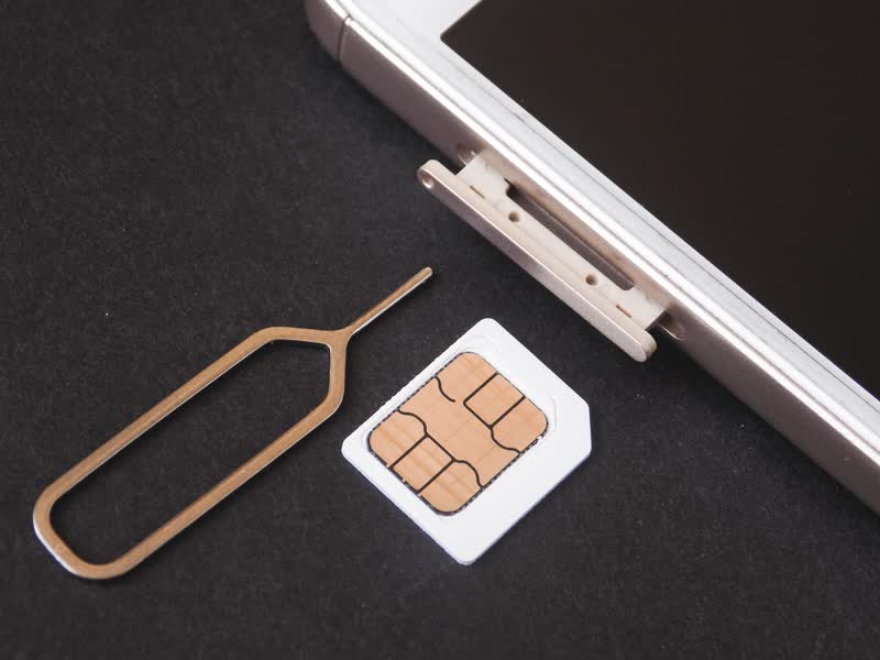 Close-up of a SIM card being removed from its tray
