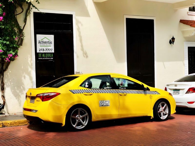 Yellow taxi parked on a street in Panama City