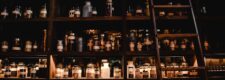 Pharmacy shelves lined with medicine jars and a wooden ladder