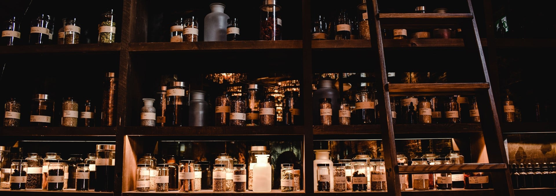 Pharmacy shelves lined with medicine jars and a wooden ladder
