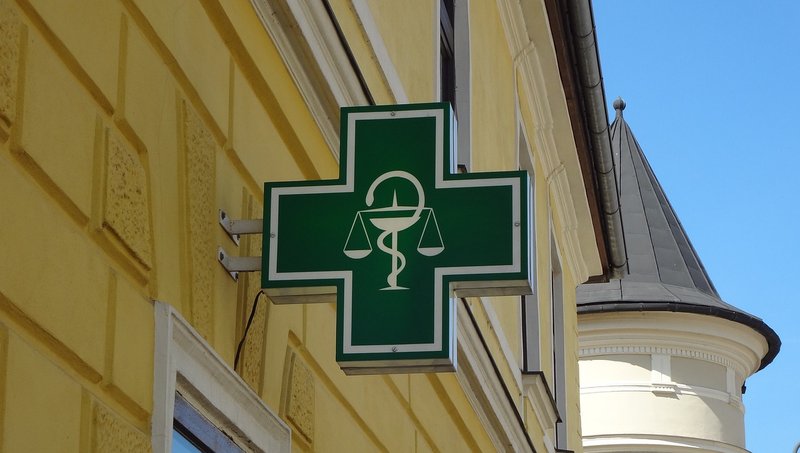 Pharmacy sign with a green cross on a building