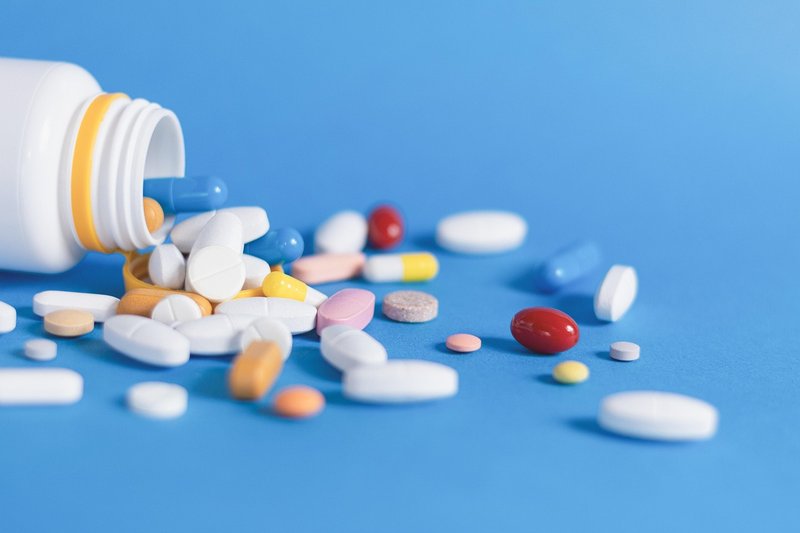 Assorted tablets and capsules spilling from a pill bottle
