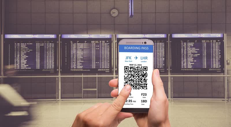 Traveler holding a phone showing a QR code at the airport